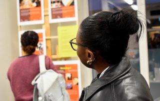 Young Black woman looking at the Mapping the Margins creative exhibition