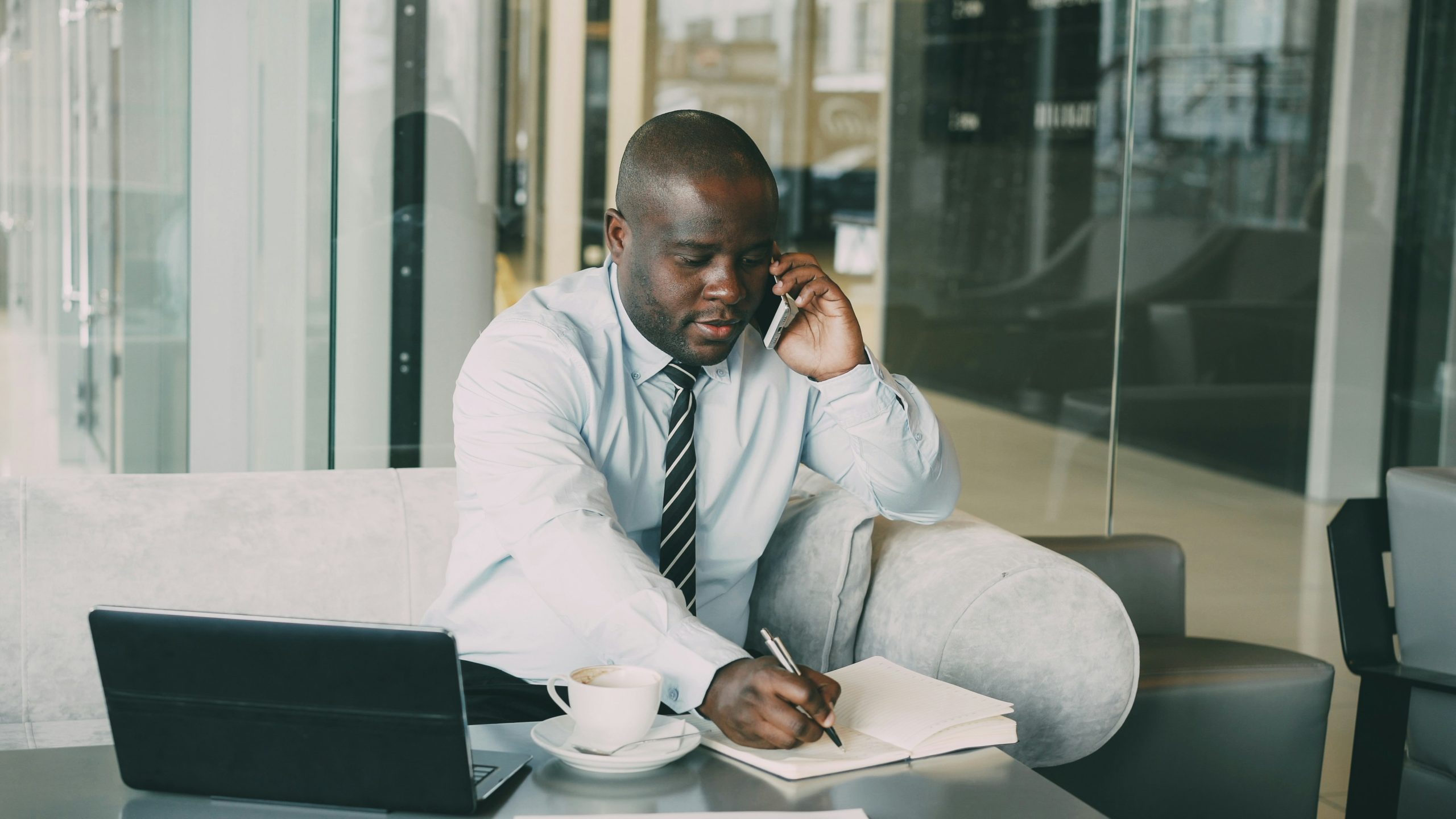 Black man working with phone and laptop
